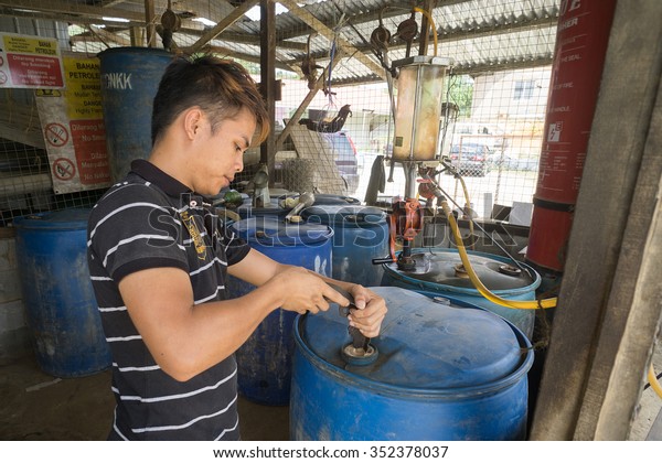 Kiulu Sabah\
Malaysia - Nov 5, 2015:Unidentified petrol fuel vendor opening a\
petrol barrel at his rural kiosk.Supply for petrol fuel in rural\
Borneo depends on small\
vendor.