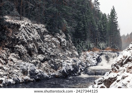 Kivach Falls on a cold snowy winter day. Landscape with snowy cascade waterfall at Suna River, Kondopoga District, Republic of Karelia, Russia