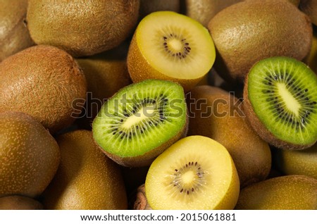 Kiwi fruit close up view of assorted fresh and juicy green and yellow kiwifruit as background.