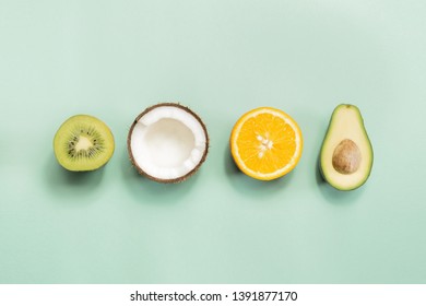 Kiwi Fruit, Coconut, Orange And Avocado On Green Background. Concept Of Fruitarianism, Vegetarianism, Veganism, Natural Vitamins And Health.