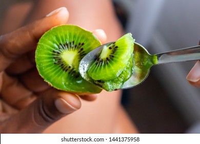 Kiwi Fruit In Hand. Girl Eating Ripe Kiwi With Tea Dessert Spoon.Summer Fruit For Healthy Diet And Vitamin C Concept