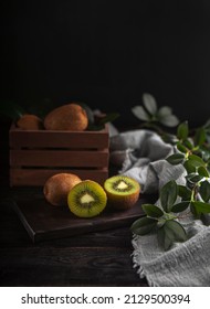 Kiwi Fruit In The Wood With Kiwi In The Wooden Box Around Grey Fabric And Green Leaves 