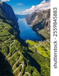 Kjerag, Lysebotn, Lysefjorden, Norway drone Aerial view of a winding road carved into the side of a steep mountain overlooking a scenic fjord in Norway.