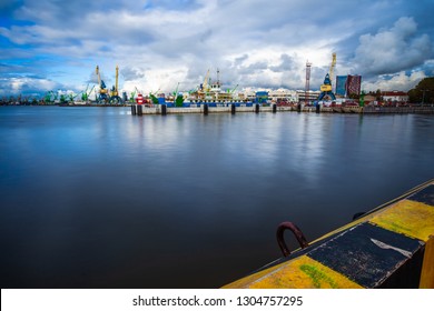 KLAIPEDA / LITHUANIA - OCTOBER 12, 2012: panorama of heavy harbor jib cranes and ships on the pier in the Klaipeda Sea Port, beautiful clouds on autumn sky