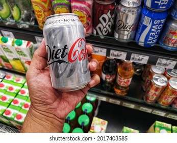Klang, Malaysia - 24 July 2021 : Hand hold a can of Diet Coke drink for sell in the supermarket with selective focus.