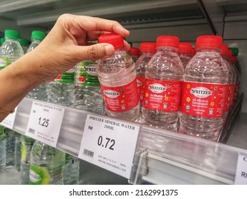 Klang, Malaysia - 29 May 2022 : Hand Pick Up A Plastic Bottle Of SPRITZER Mineral Water For Sell On The Supermarket Shelf With Selective Focus.