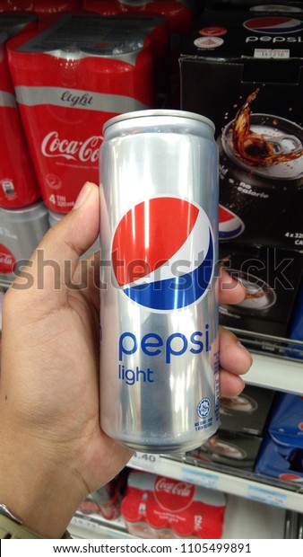 Klang, Malaysia - June\
2, 2018 : Hand hold a can of PEPSI Light carbonated soft drink at\
the supermarket.\
\
