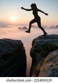 Kleiner Winterberg, Germany. June 27 2021. Fearless Sport Body Woman Jump Over Gulch Between Rocky Edges. Crazy Activities And Adventure