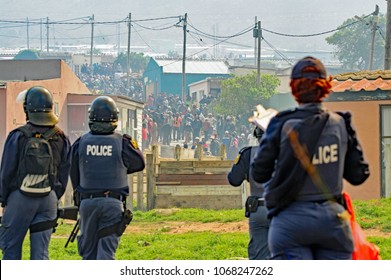 Kleinmond, Western Cape, South Africa, September 11th 2017. With The Crowd Baiting Them, Members Of The Riot Police Keep Close Watch On Violent Protesters During Illegal Protest Action And Riots.