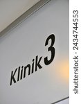 Klinik 3 sign on a glass door of a dental clinic.