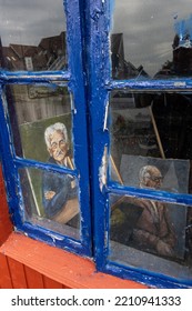 Klintholm, Denmark Oct 4, 2022 Painted Portraits Of Older Men Seen In The Window Of A Small Art Studio.