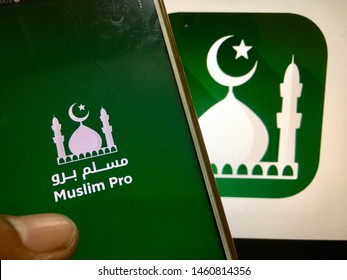 Kluang, Johor / Malaysia - July 25, 2019 : A Man Holding The Muslim Pro Apps In Front Muslim Pro Wallpaper On Macbook Pro. Muslim Pro Is The Best Islamic Apps.