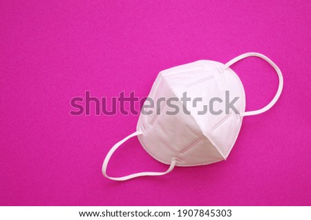 KN95 or N95 FFP2 mask for protection pm 2.5 and corona virus (COVID-19). Anti pollution mask.air face mask, N95 FFP2 mask on pink background.   Stock photo © 