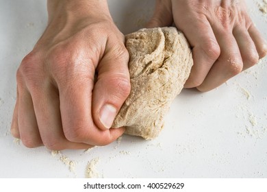 Kneading dough . Close up image of a young woman's hands kneading wholegrain dough. - Shutterstock ID 400529629
