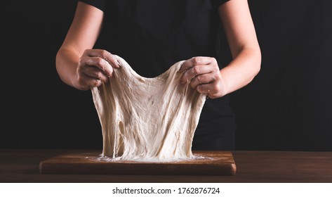 Kneading the dough method stretch end fold. 
Women's hands and dough - Powered by Shutterstock