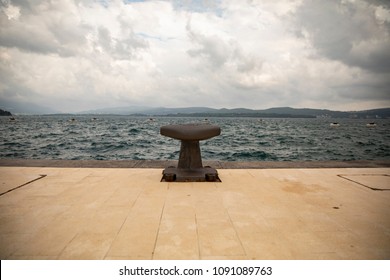 Knecht. In the port on the dock a lonely bollard looks at the sea and awaits his ship. In each port the mooring bollard is the most necessary thing. On a rainy day, however, all the ships are in their - Powered by Shutterstock