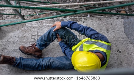 Knee accident at work of construction worker at site. Builder accident falls scaffolding on floor.