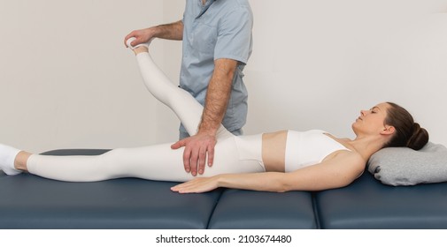 Knee Pain Relief In Clinic. Doctor Physiotherapist Doing Healing Treatment On Patient Leg. Therapist Giving Leg And Calf Massage. Osteopathy, Chiropractic Leg Adjustment. Chiropractic Treatment.