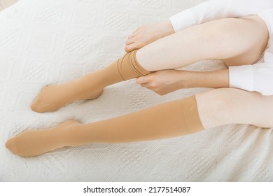 Knee socks or socks. Beige compression stockings on a woman in a white room. Girl putting on stockings at home. Beautiful female legs. - Shutterstock ID 2177514087