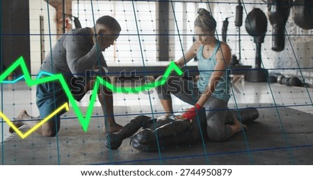 Kneeling coach coaching trainee doing CPR on mannequin, gym with data overlay, red wraps. Instructor, lifesaving, firstaid, training, teamwork, fitness, windows
