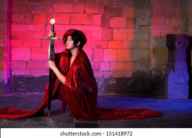 Kneeling Gothic Woman With A Sword In A Medieval Castle