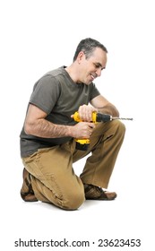 Kneeling handyman pushing on his cordless drill
