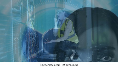 Kneeling IT tech holding smartphone, explaining server rack cables in data center, with HUD overlay. Networking, technology, collaboration, digital, connectivity, industrial, professional