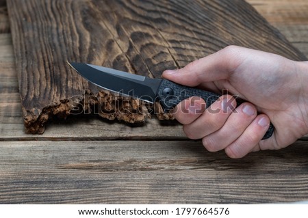 Knife clamped in hand. Hit with a knife. Stab with a knife. Front view.