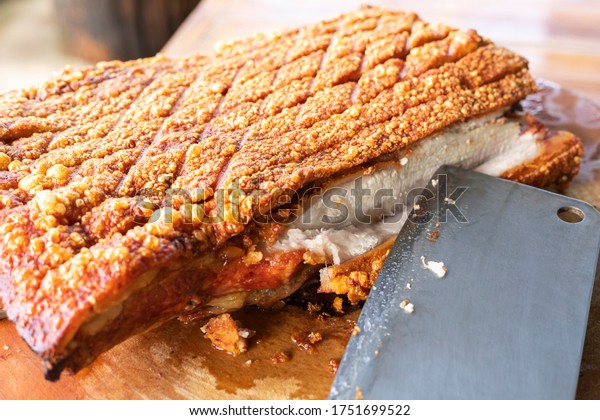 knife cut\
divide crispy pork on wooden chopping\
board