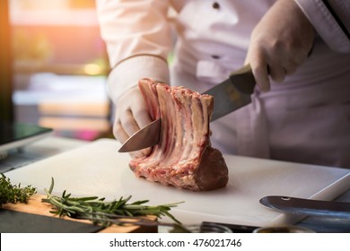 Knife Cutting Meat With Bone. Hand Of Chef With Knife. Prepare Veal Ribs For Lunch. One Of The Secret Recipes.