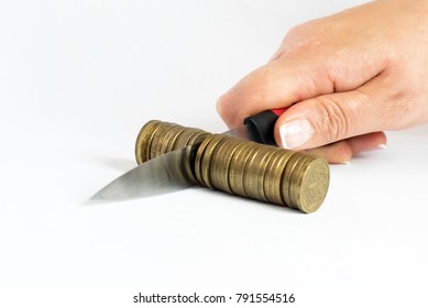Knife cutting a pile of coin. Concept of budget cuts, savings, recession, commission, cash back, taxes