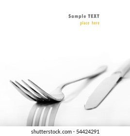 A Knife And Fork Stacked Up On A Pure White Background