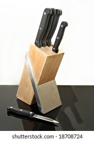 Knife set and block reflected on black bench