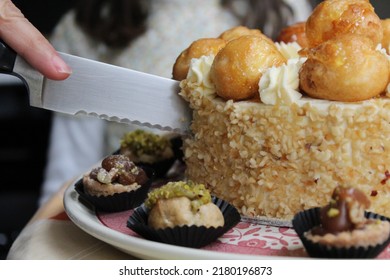 A Knife Slicing Through Some Cake, With Petit-fours Around It