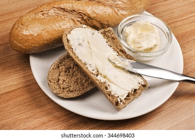 A Knife Spreading Butter On Bread