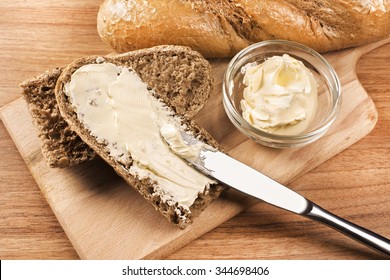 A Knife Spreading Butter On Bread