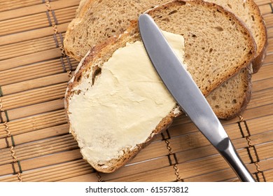 A Knife Spreading Butter On Bread