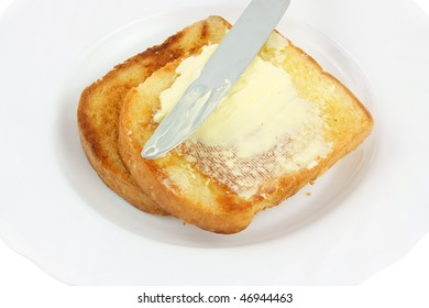 Knife Spreading Butter On Toast In White Plate