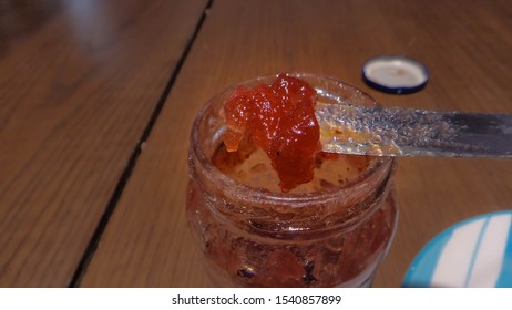 Knife Taking Out Stawberry Jam From A Glass Jar