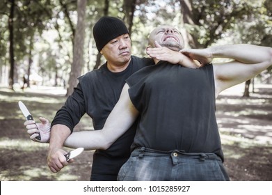 Knife Vs Knife Fight. Filipino Martial Arts Instructor Demonstrates Self Defense Disarming Technique Against Threat And Knife Attack