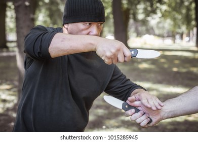 Knife Vs Knife Fight. Filipino Martial Arts Instructor Demonstrates Self Defense Disarming Technique Against Threat And Knife Attack