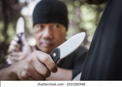 Knife Vs Knife Fight. Filipino Martial Arts Instructor Demonstrates Self Defense Disarming Technique Against Threat And Knife Attack