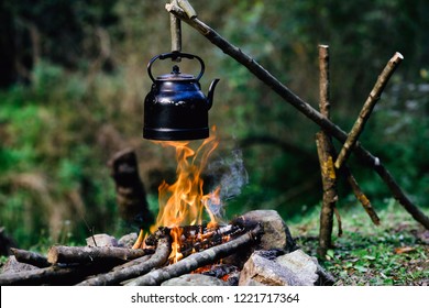 With Knife, Water Bottle And Titanium Mug Near The Fire Outdoors. Bushcraft, Adventure, Travel, Tourism And Camping Concept.