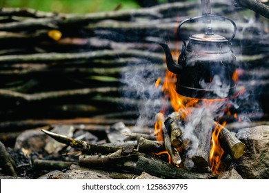 With Knife, Water Bottle And Titanium Mug Near The Fire Outdoors. Bushcraft, Adventure, Travel, Tourism And Camping Concept.