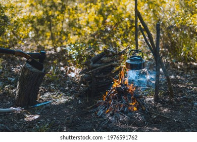 With Knife, Water Bottle And Titanium Mug Near The Fire Outdoors. Bushcraft, Adventure, Travel, Tourism And Camping Concept.