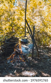 With Knife, Water Bottle And Titanium Mug Near The Fire Outdoors. Bushcraft, Adventure, Travel, Tourism And Camping Concept.