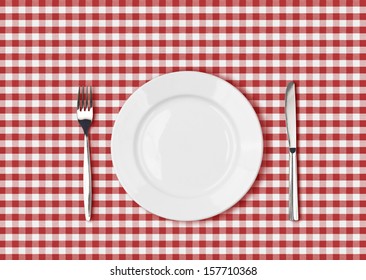 Knife, White Plate And Fork On Red Picnic Table Cloth