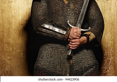 Knight holding sword on golden background.
