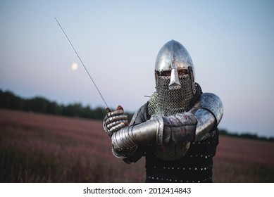 A knight with a sword battles on the battlefield on a dark sky background.