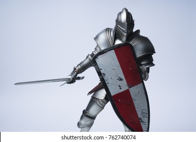 Рыцарь с мечом и красным клетчатым щитом на изолированном фоне